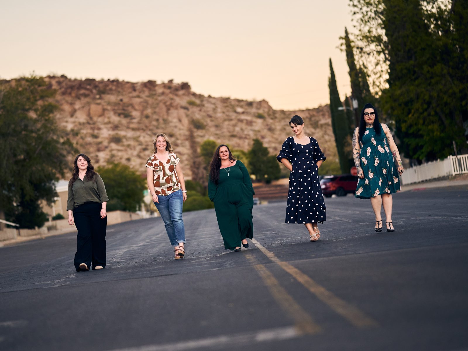 The Liberating Love team walking down a desert road at sunset