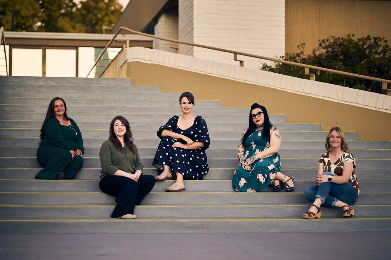 The Liberating Love team sitting together on the steps